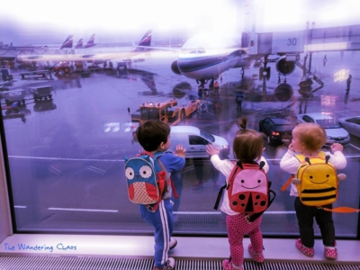 Three toddlers looking at a plane on the tarmac
